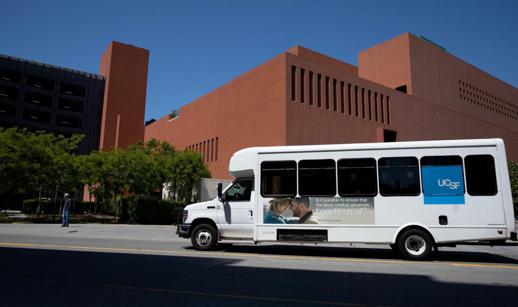 UCSF shuttle driving North on Owens Street, with the Rutter Center in the background, at Mission Bay.